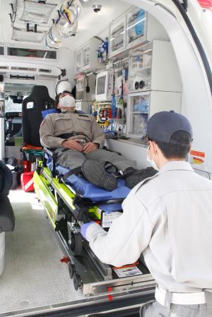 電動ストレッチャーを使用して傷病者を救急車内に運び入れる写真