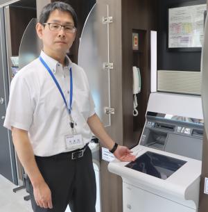 ATMを案内する山田さん