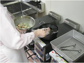 専用の調理室で揚げ物調理をする様子